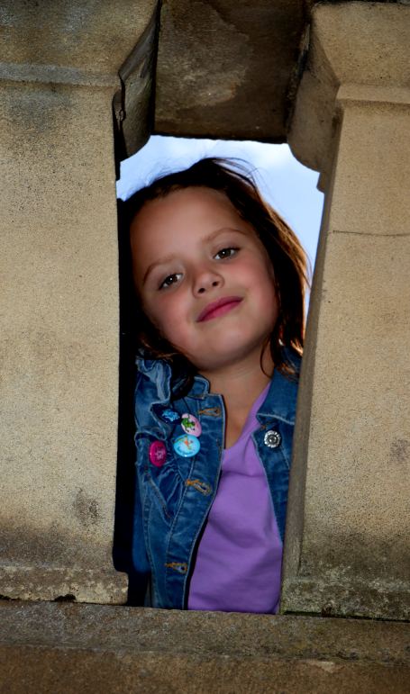 Young girl with dark hair, purple t-shirt and denim jacket 